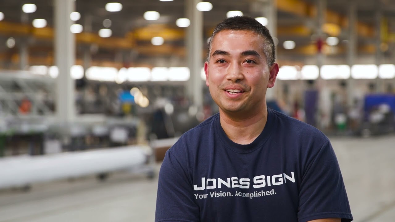 Poster image of Jones Sign Co employee discussing the workplace & environment